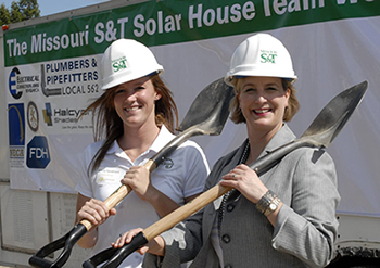 Women with hard hats and shovels