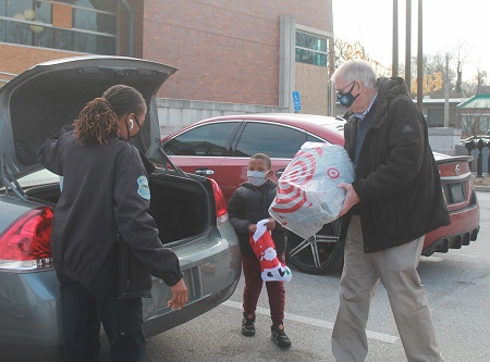 Electrical Connection Executive Vice President Jim Curran loads gifts during the Ferguson “Shop with a Cop.”