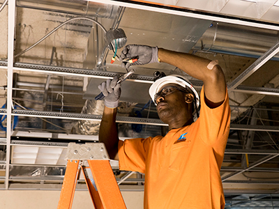 Electrician in hard hat wiring building